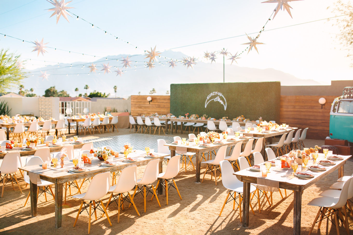 Wedding reception with stars and white bucket chairs | Pink and orange Lautner Compound wedding | Colorful Palm Springs wedding photography | #palmspringsphotographer #palmspringswedding #lautnercompound #southerncaliforniawedding  Source: Mary Costa Photography | Los Angeles