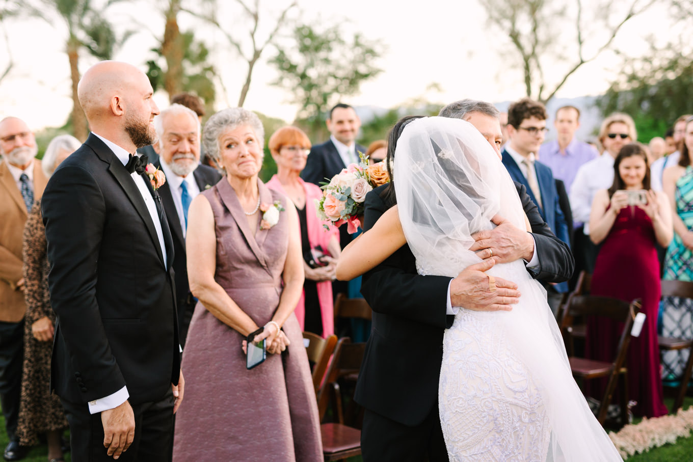 Father hugging Bride | Pink Bougainvillea Estate wedding | Colorful LA wedding photography | #bougainvilleaestate #palmspringswedding #palmspringsweddingvenue #palmspringsphotographer Source: Mary Costa Photography | Los Angeles
