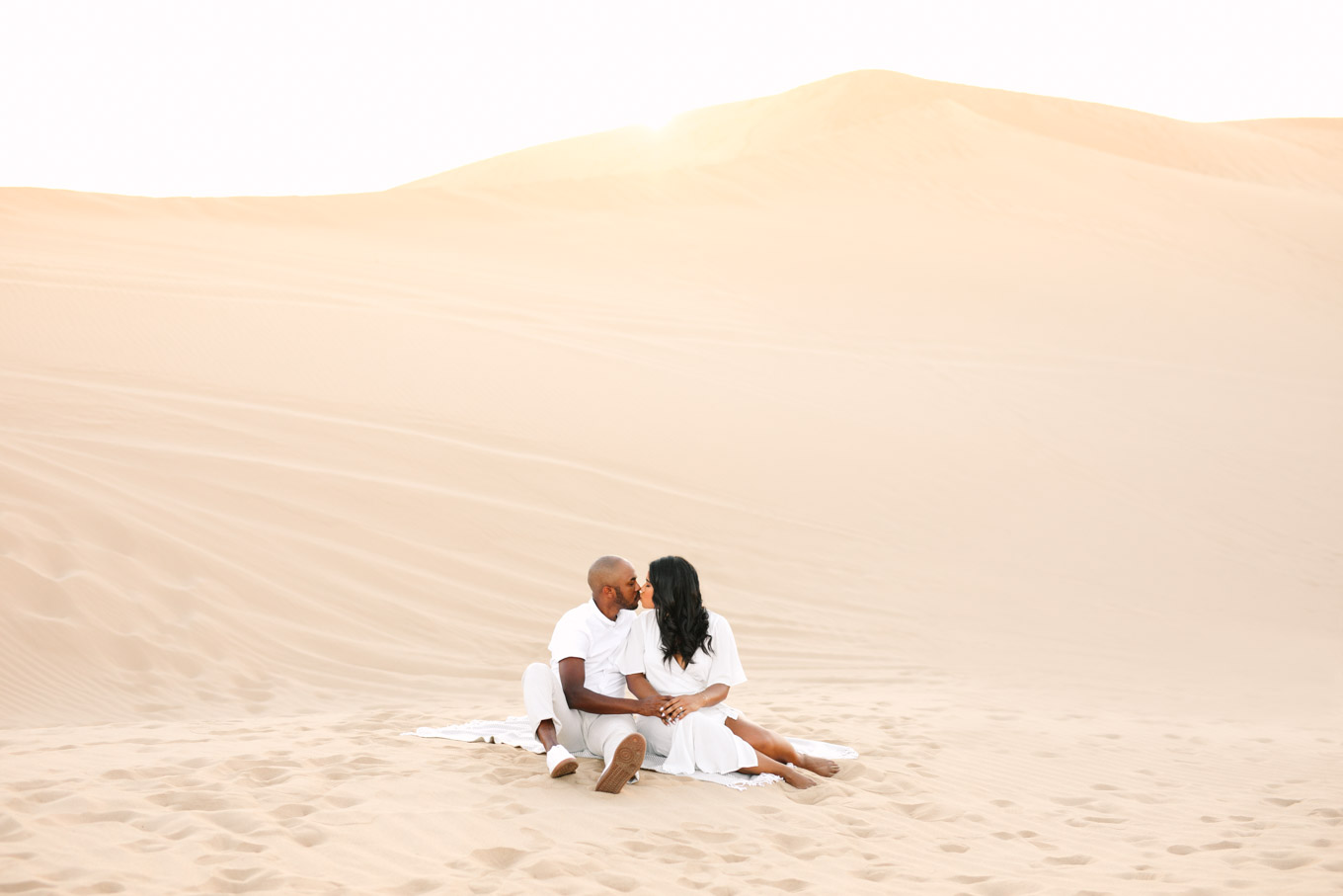Engaged couple sharing a kiss on sand dune | California Sand Dunes engagement session | Colorful Palm Springs wedding photography | #palmspringsphotographer #sanddunes #engagementsession #southerncalifornia  Source: Mary Costa Photography | Los Angeles