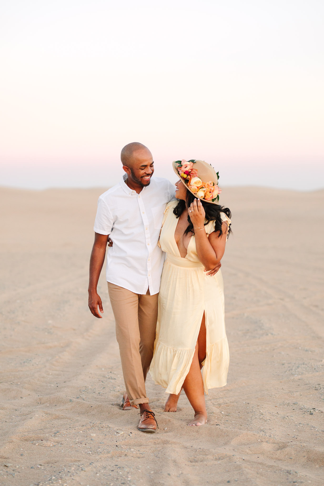 Happy couple walking on sand dune at sunset | California Sand Dunes engagement session | Colorful Palm Springs wedding photography | #palmspringsphotographer #sanddunes #engagementsession #southerncalifornia  Source: Mary Costa Photography | Los Angeles