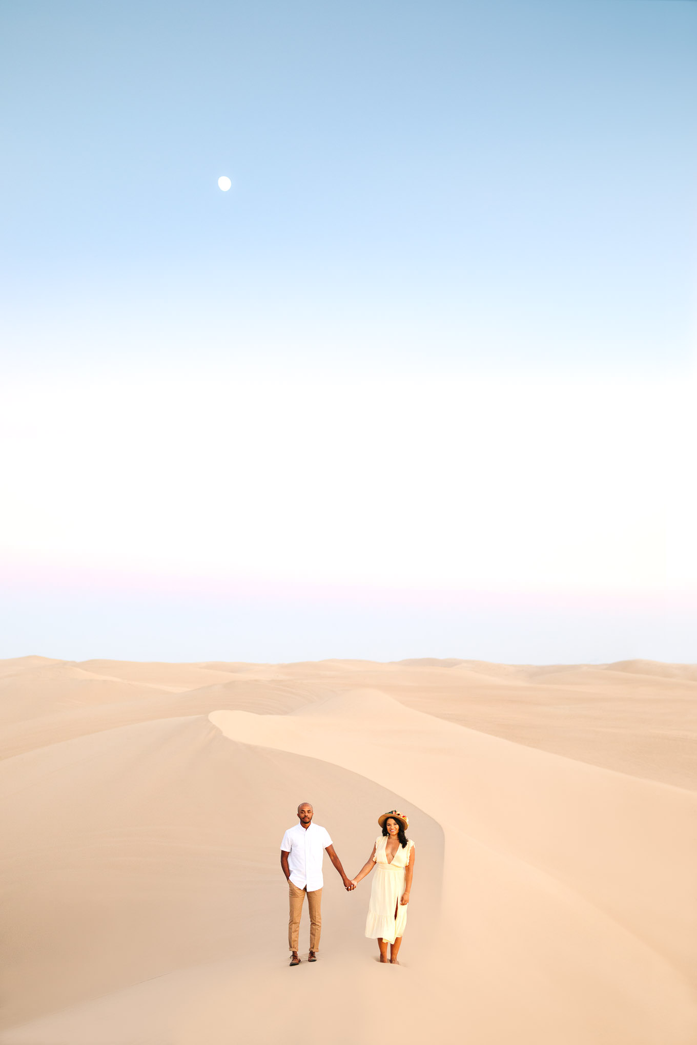 Engaged couple walking the along a sand dune at sunset | California Sand Dunes engagement session | Colorful Palm Springs wedding photography | #palmspringsphotographer #sanddunes #engagementsession #southerncalifornia  Source: Mary Costa Photography | Los Angeles
