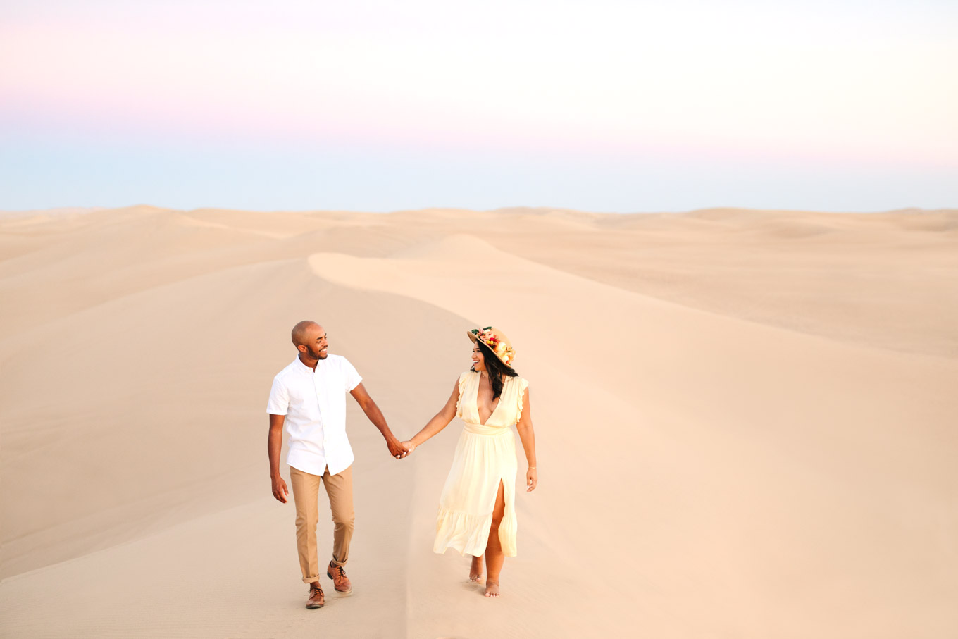Engaged couple walking hand in hand on sand dune | California Sand Dunes engagement session | Colorful Palm Springs wedding photography | #palmspringsphotographer #sanddunes #engagementsession #southerncalifornia  Source: Mary Costa Photography | Los Angeles