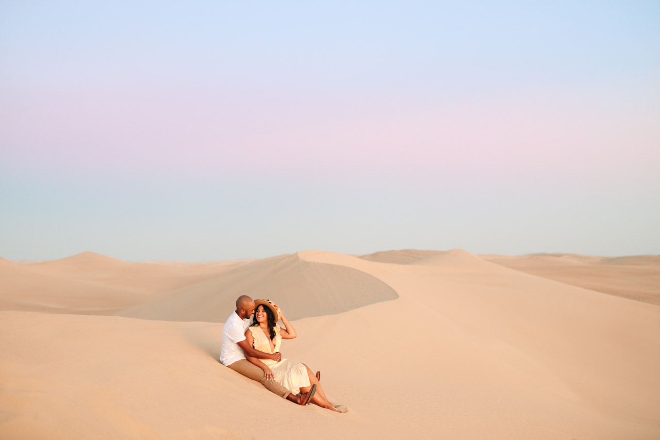 Wispy clouds above sand dune with engaged couple | California Sand Dunes engagement session | Colorful Palm Springs wedding photography | #palmspringsphotographer #sanddunes #engagementsession #southerncalifornia  Source: Mary Costa Photography | Los Angeles