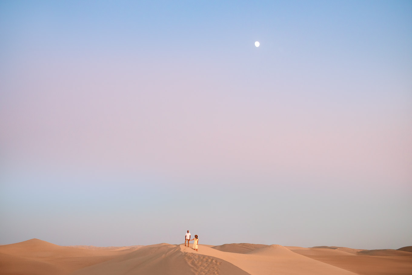 Distant view of engaged couple with beautiful sky on sand dunes | California Sand Dunes engagement session | Colorful Palm Springs wedding photography | #palmspringsphotographer #sanddunes #engagementsession #southerncalifornia  Source: Mary Costa Photography | Los Angeles