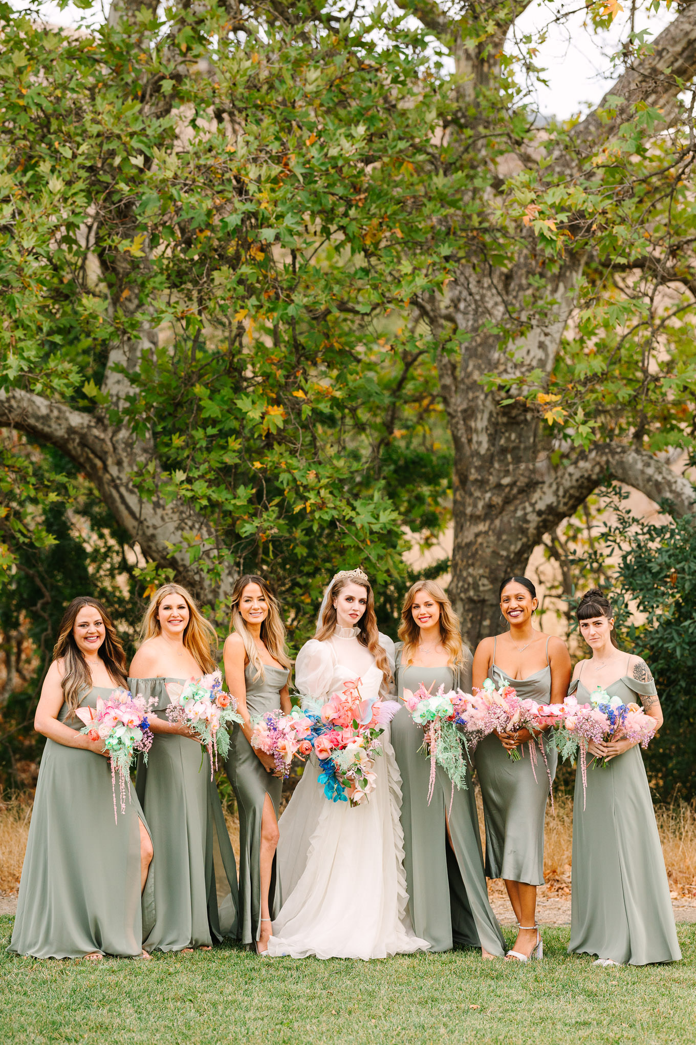 Bridesmaids in sage green gowns with colorful bouquets | Colorful and quirky wedding at Higuera Ranch in San Luis Obispo | #sanluisobispowedding #californiawedding #higueraranch #madonnainn   Source: Mary Costa Photography | Los Angeles