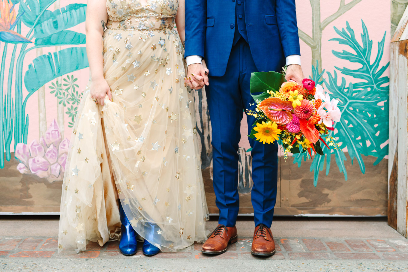 Bride with bright blue boots and groom holding bouquet in front of mural | Colorful Downtown Los Angeles Valentine Wedding | Los Angeles wedding photographer | #losangeleswedding #colorfulwedding #DTLA #valentinedtla   Source: Mary Costa Photography | Los Angeles