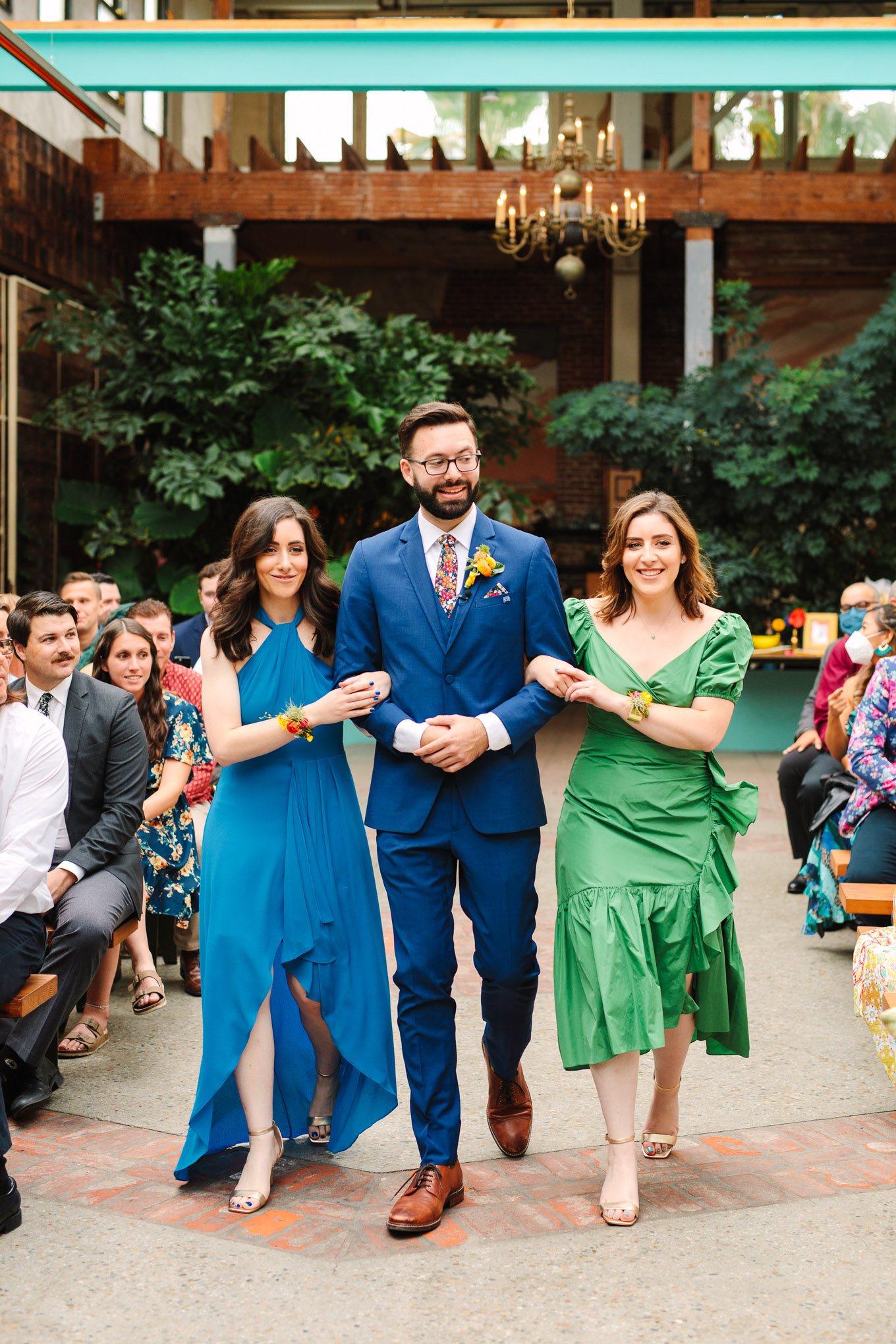 Groom walking down the aisle with sisters | Colorful Downtown Los Angeles Valentine Wedding | Los Angeles wedding photographer | #losangeleswedding #colorfulwedding #DTLA #valentinedtla   Source: Mary Costa Photography | Los Angeles