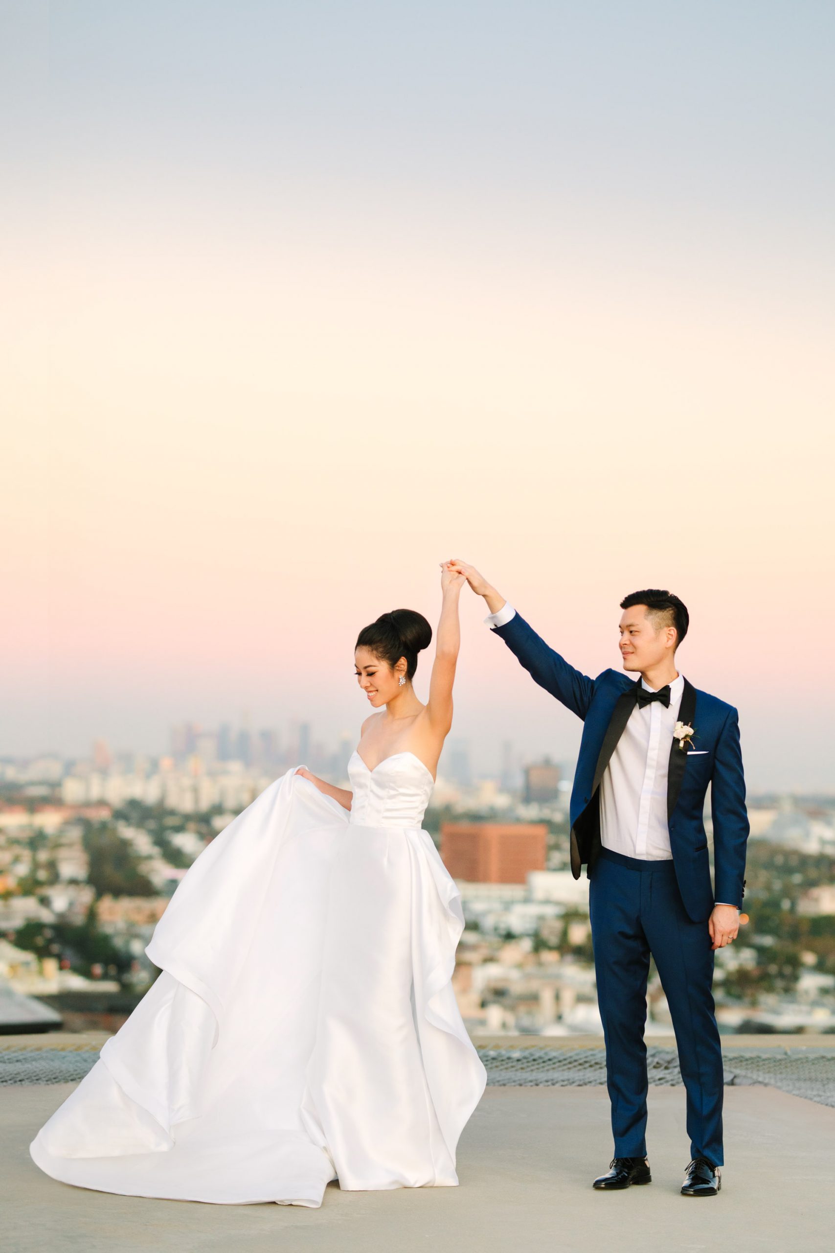 Couple twirling on rooftop in Los Angeles Indian Fusion wedding at Fig House Los Angeles by Mary Costa Photography