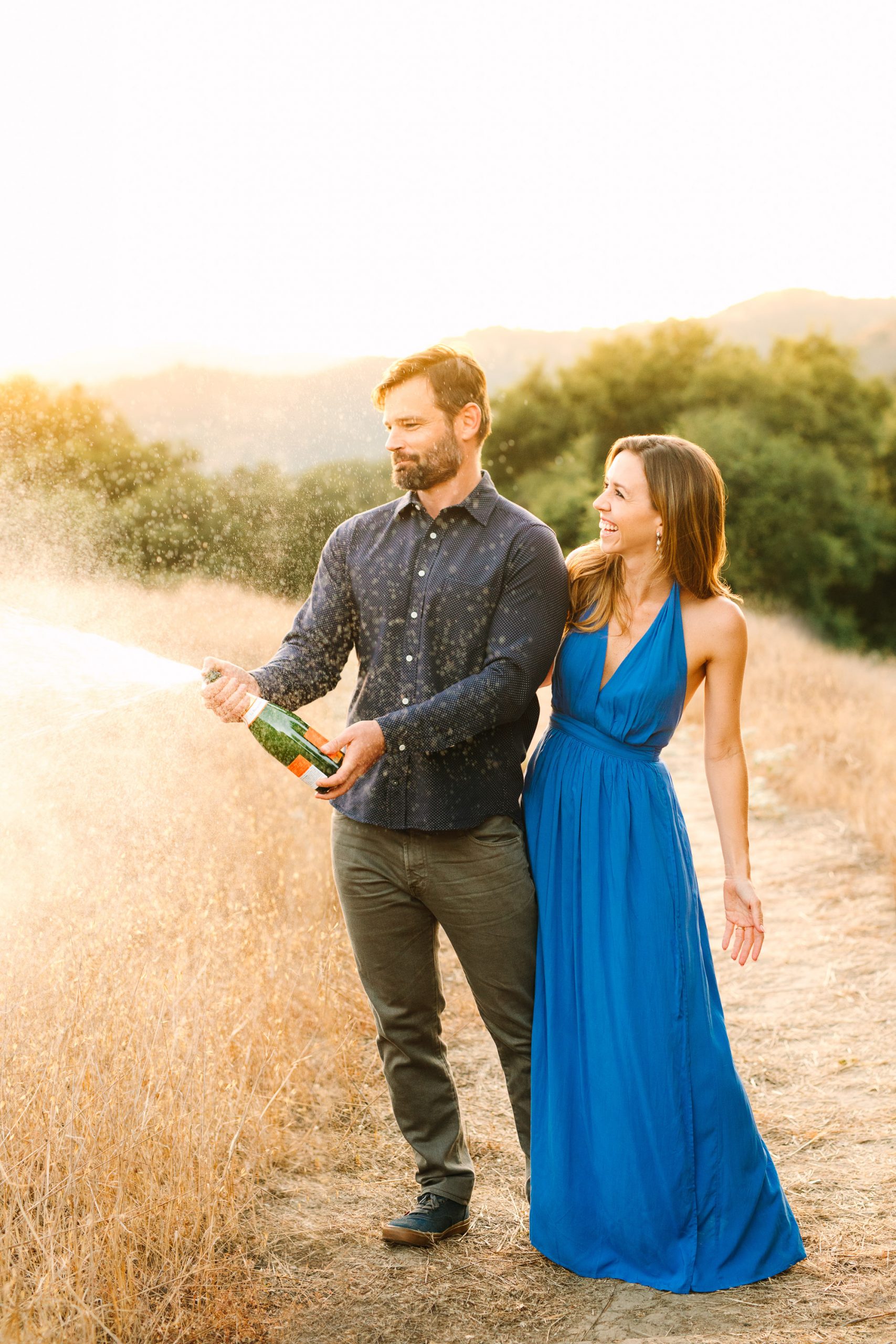 Couple popping champagne by Mary Costa Photography