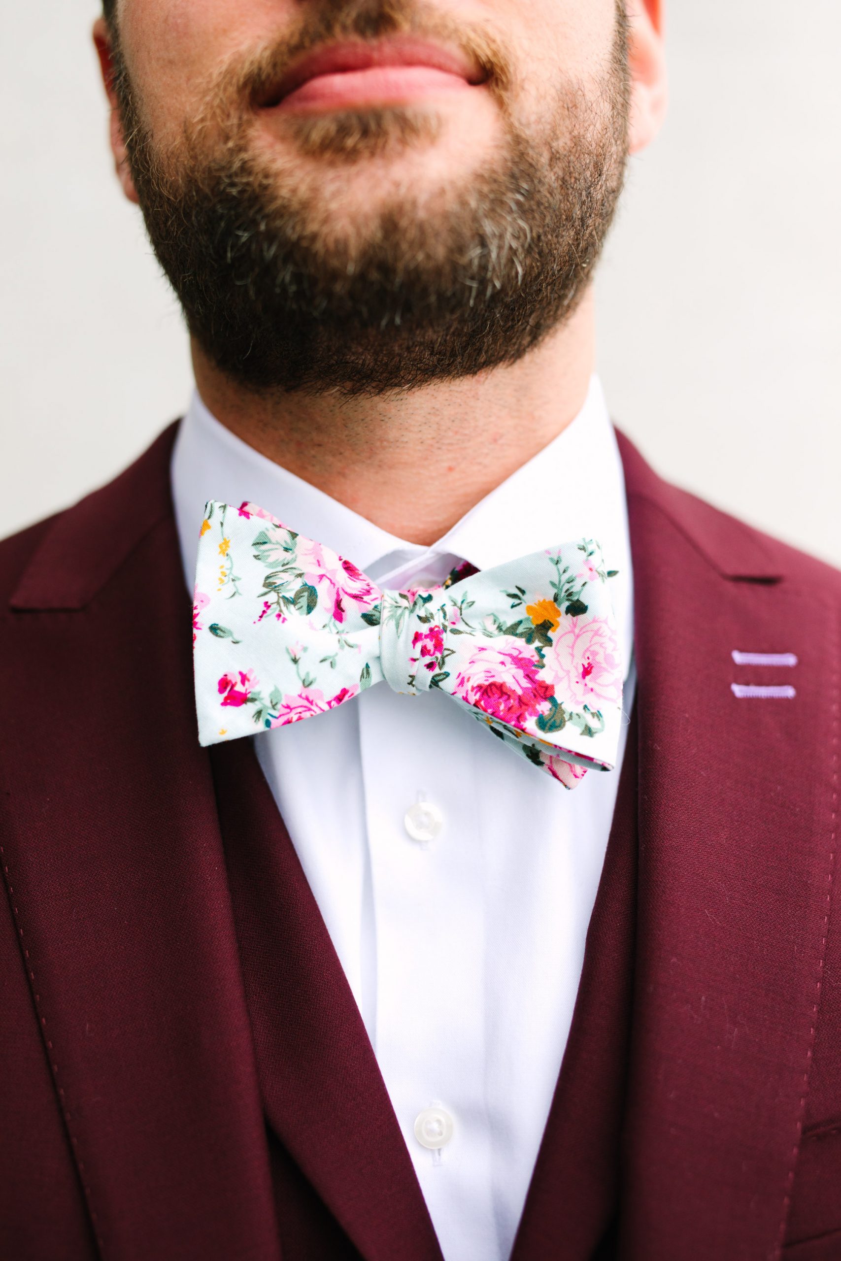 Floral bowtie by Groom getting ready in emerald tux by Mary Costa Photography