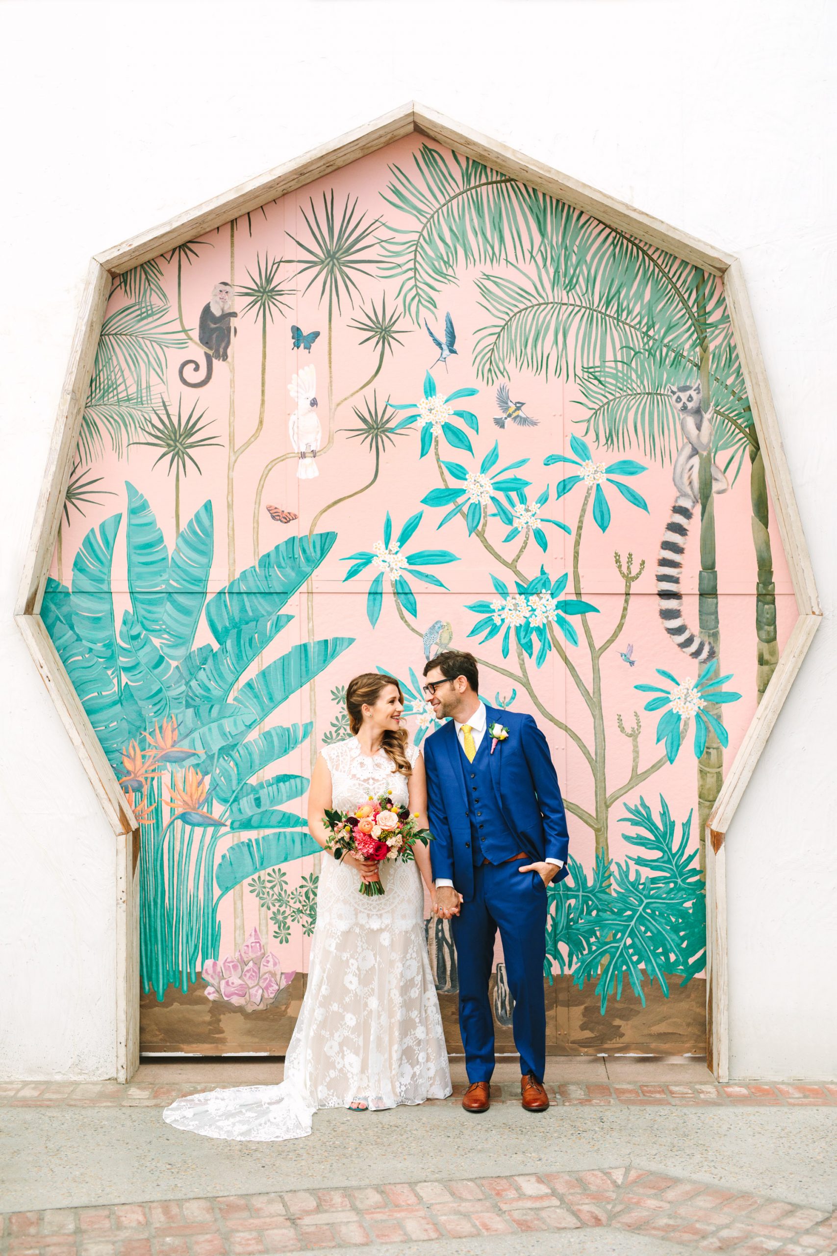 Bride and groom laughing in front of colorful door at Valentine DTLA - www.marycostaweddings.com