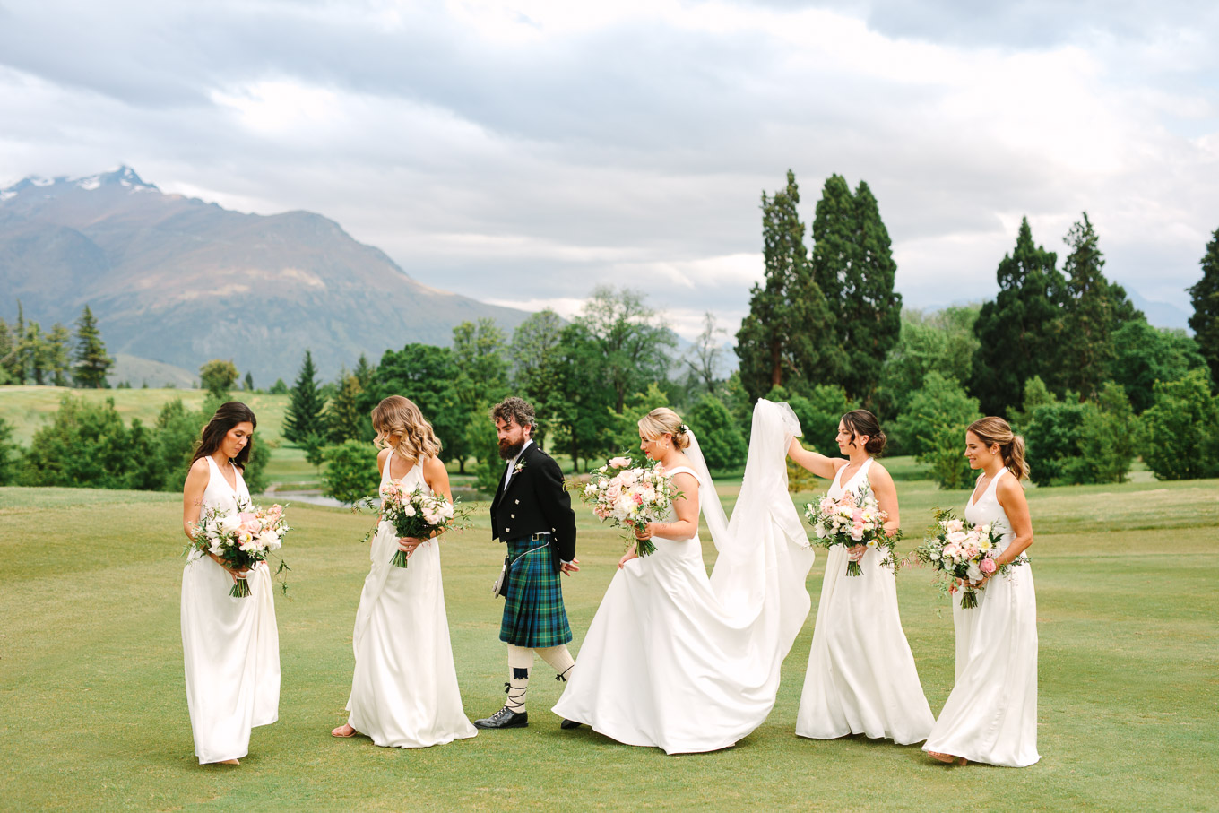 Bridal party walking among the mountains. Millbrook Resort Queenstown New Zealand wedding by Mary Costa Photography | www.marycostaweddings.com