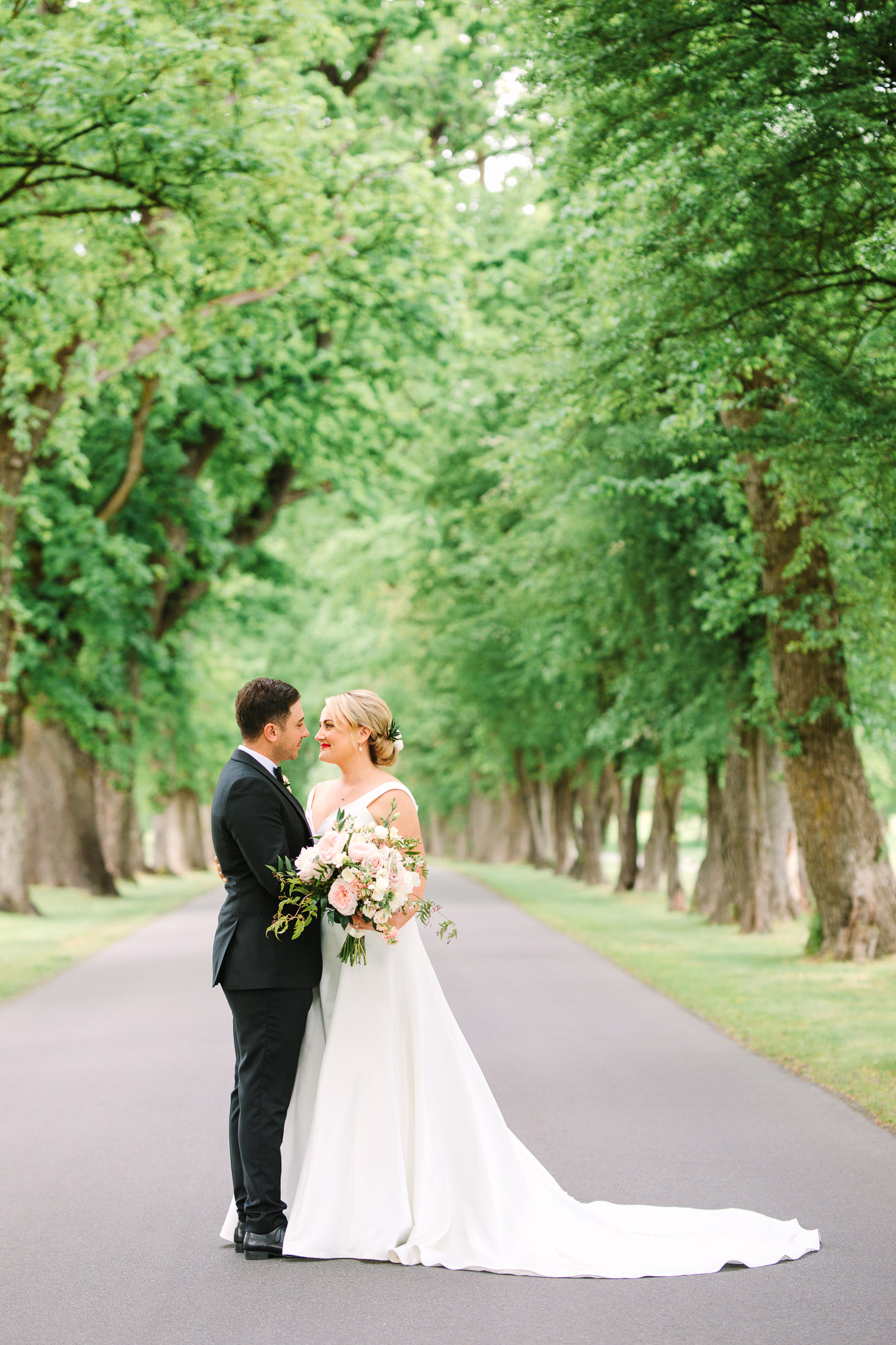 Bride and groom portrait in tree-lined road. Millbrook Resort Queenstown New Zealand wedding by Mary Costa Photography | www.marycostaweddings.com