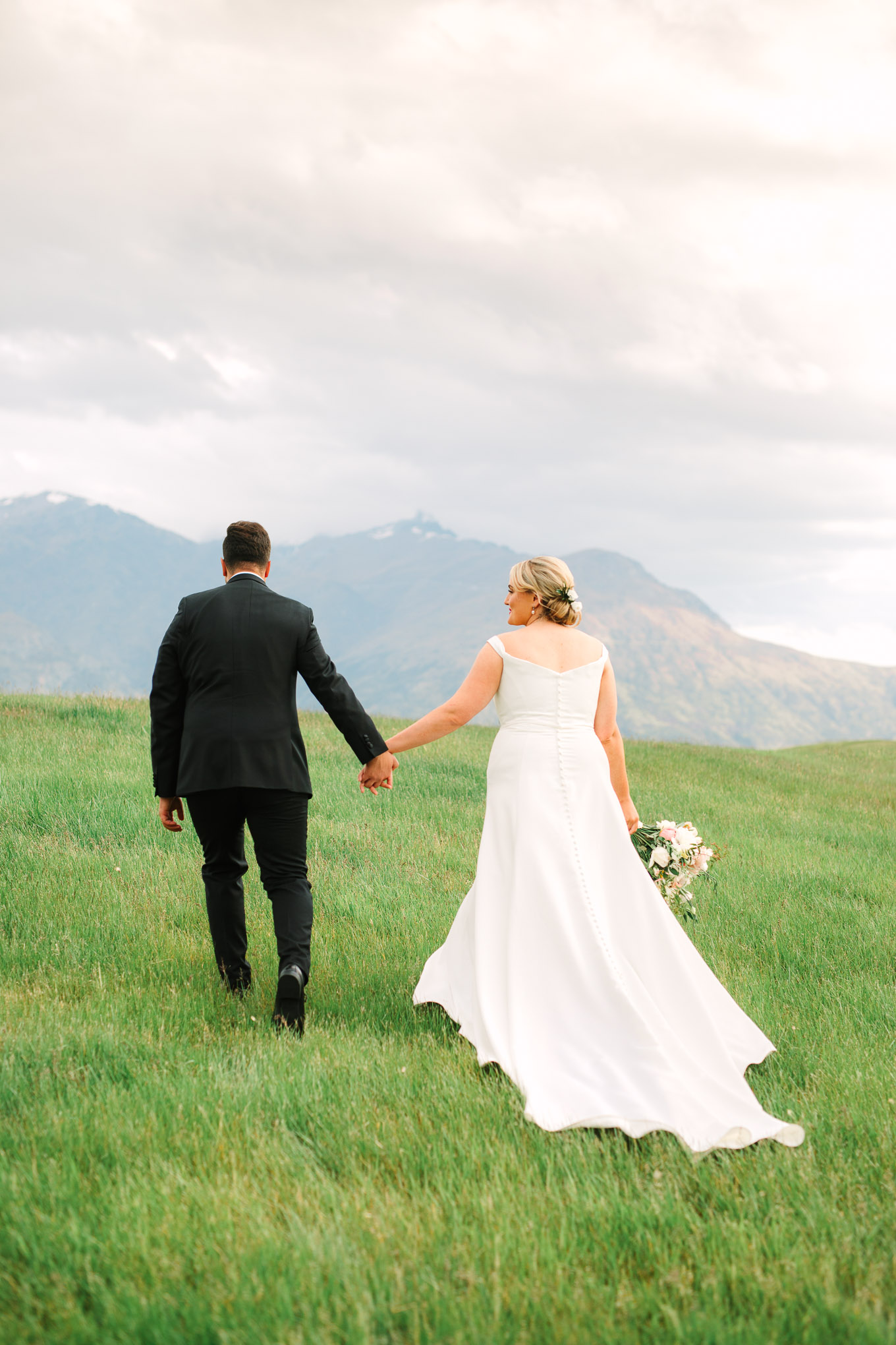 Wedding portrait on a hillside with Southern Alps in the background. Millbrook Resort Queenstown New Zealand wedding by Mary Costa Photography | www.marycostaweddings.com