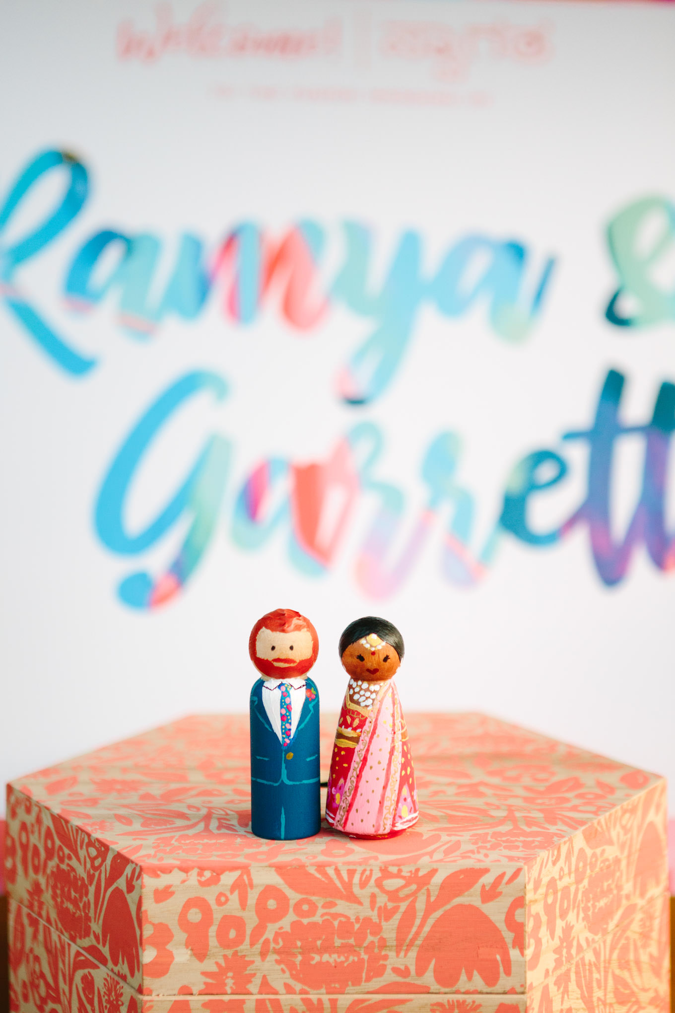 Mini custom wood painted cake toppers of bride and groom. Two Disney artists create a unique and colorful Indian Fusion wedding at The Fig House Los Angeles, featured on Green Wedding Shoes. | Colorful and elevated wedding inspiration for fun-loving couples in Southern California | #indianwedding #indianfusionwedding #thefighouse #losangeleswedding   Source: Mary Costa Photography | Los Angeles