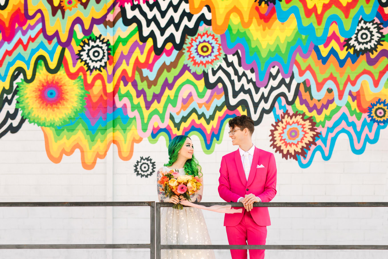 Rainbow mural with groom in hot pink suit and bride with green hair | Engagement, elopement, and wedding photography roundup of Mary Costa’s favorite images from 2020 | Colorful and elevated photography for fun-loving couples in Southern California | #2020wedding #elopement #weddingphoto #weddingphotography   Source: Mary Costa Photography | Los Angeles