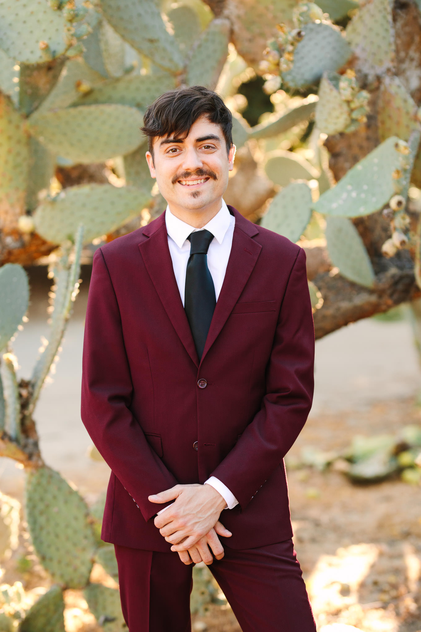 Groom in burgundy suit with black tie | Los Angeles Arboretum Elopement | Colorful and elevated wedding photography for fun-loving couples in Southern California | #LosAngelesElopement #elopement #LAarboretum #LAskyline #elopementphotos   Source: Mary Costa Photography | Los Angeles