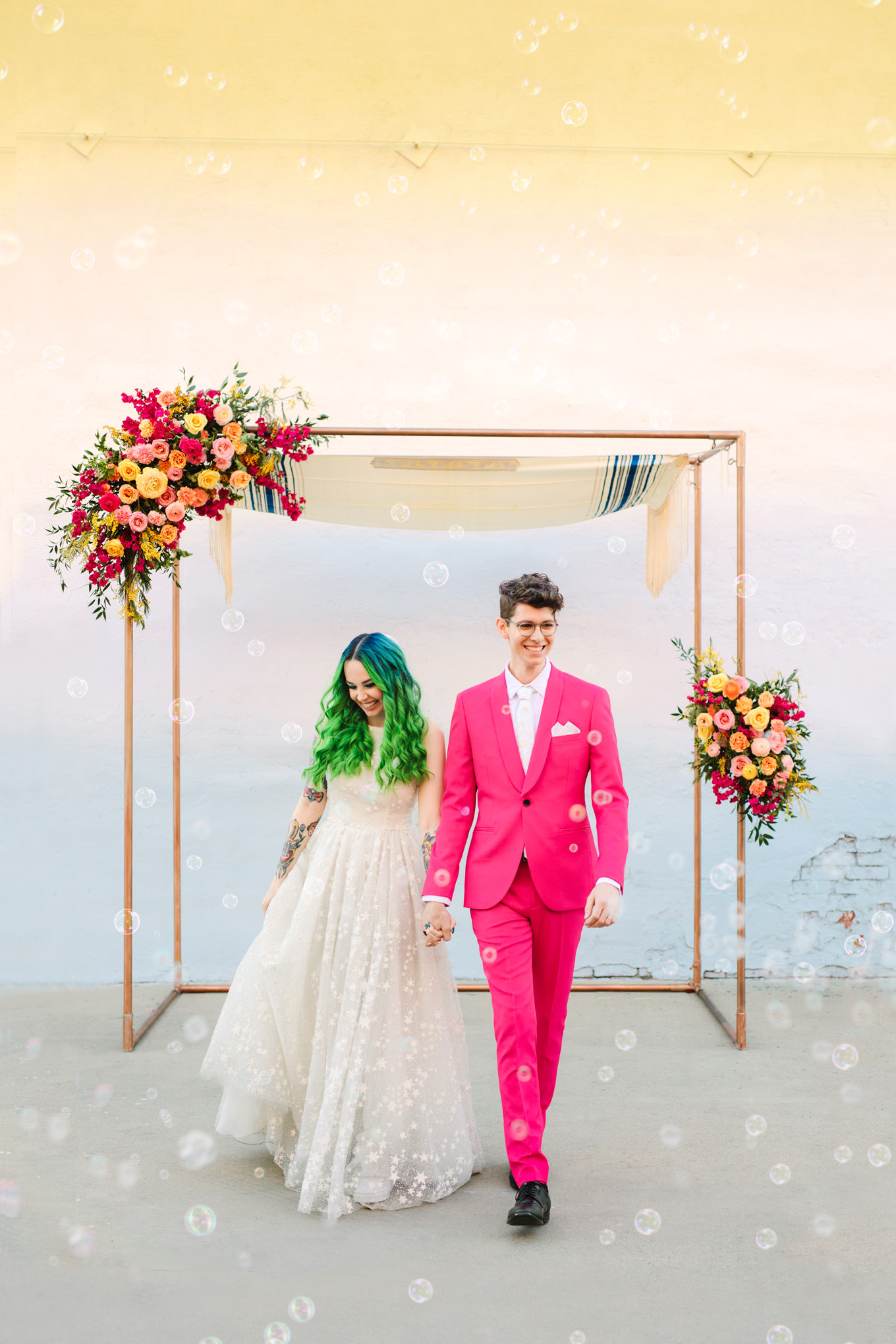 Groom in hot pink suit and bride with green hair in bubble ceremony exit | Colorful wedding at The Unique Space Los Angeles published in The Knot Magazine | Fresh and colorful photography for fun-loving couples in Southern California | #colorfulwedding #losangeleswedding #weddingphotography #uniquespace Source: Mary Costa Photography | Los Angeles
