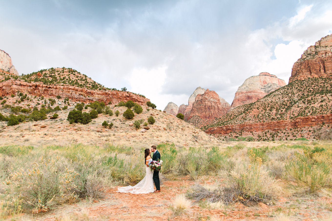 Groom in green suit with bride in Zion National Park | Zion National Park elopement | Colorful adventure elopement photography | #utahelopement #zionelopement #zionwedding #undercanvaszion   Source: Mary Costa Photography | Los Angeles