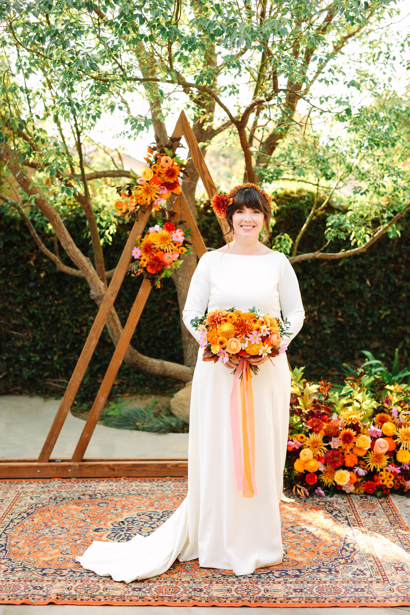 Bride in front of unique wedding ceremony backdrop | Vibrant backyard micro wedding featured on Green Wedding Shoes | Colorful LA wedding photography | #losangeleswedding #backyardwedding #microwedding #laweddingphotographer Source: Mary Costa Photography | Los Angeles