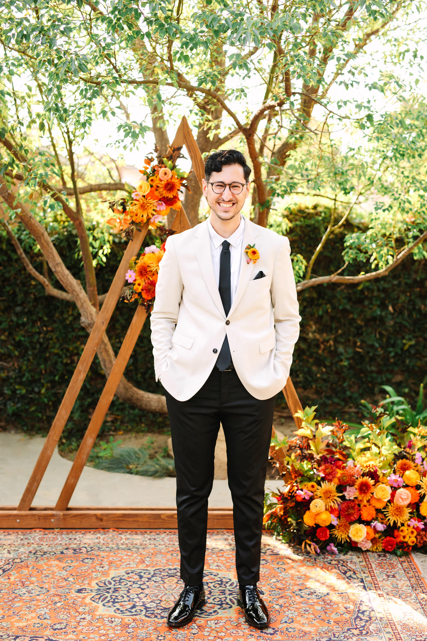 Groom portrait in front of unique wedding backdrop | Vibrant backyard micro wedding featured on Green Wedding Shoes | Colorful LA wedding photography | #losangeleswedding #backyardwedding #microwedding #laweddingphotographer Source: Mary Costa Photography | Los Angeles