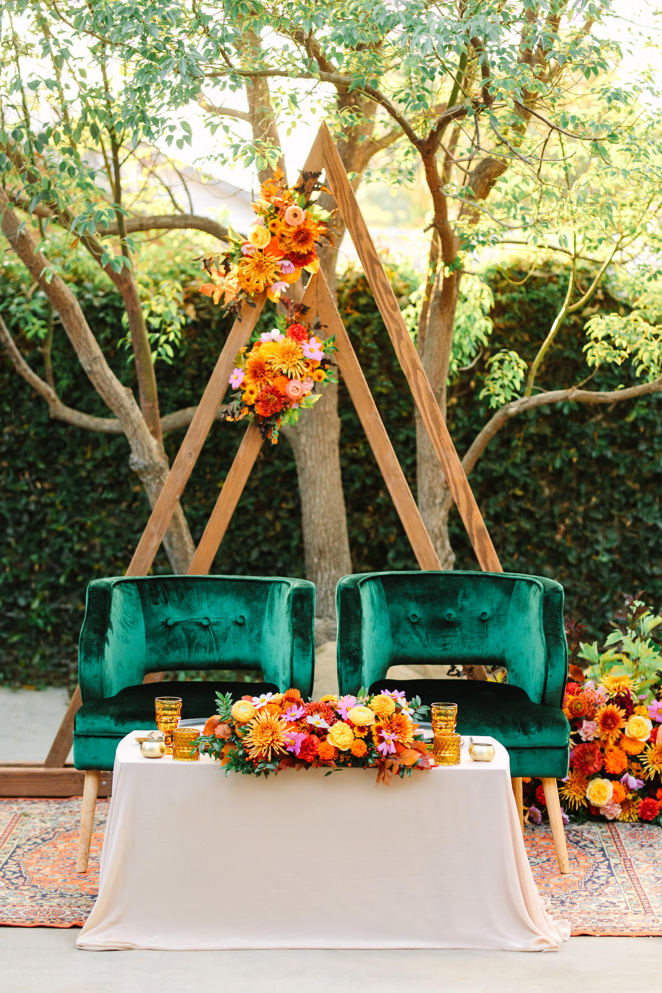 Unique seating with green velvet chairs and strikingly bold floral arrangements | Vibrant backyard micro wedding featured on Green Wedding Shoes | Colorful LA wedding photography | #losangeleswedding #backyardwedding #microwedding #laweddingphotographer Source: Mary Costa Photography | Los Angeles