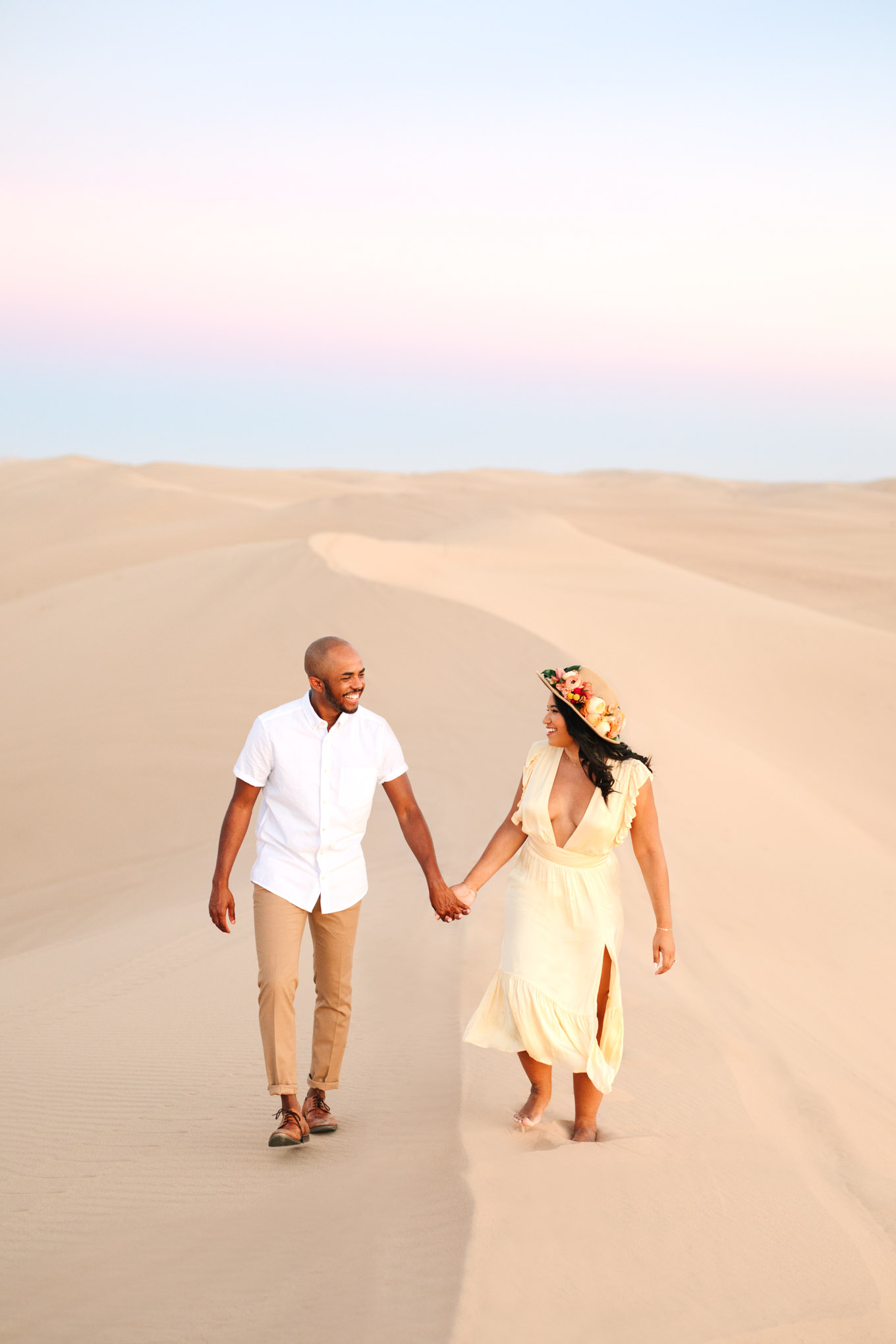 Engaged couple walking the along a sand dune at sunset | California Sand Dunes engagement session | Colorful Palm Springs wedding photography | #palmspringsphotographer #sanddunes #engagementsession #southerncalifornia  Source: Mary Costa Photography | Los Angeles