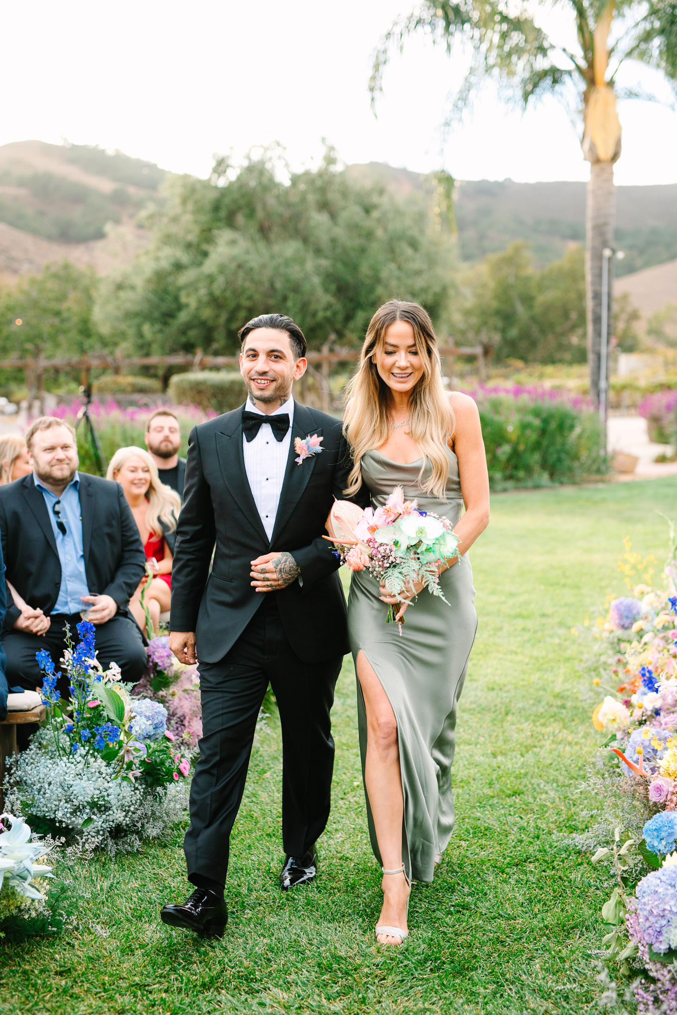 Bridesmaid and groomsman walking down the aisle | Colorful and quirky wedding at Higuera Ranch in San Luis Obispo | #sanluisobispowedding #californiawedding #higueraranch #madonnainn   
Source: Mary Costa Photography | Los Angeles