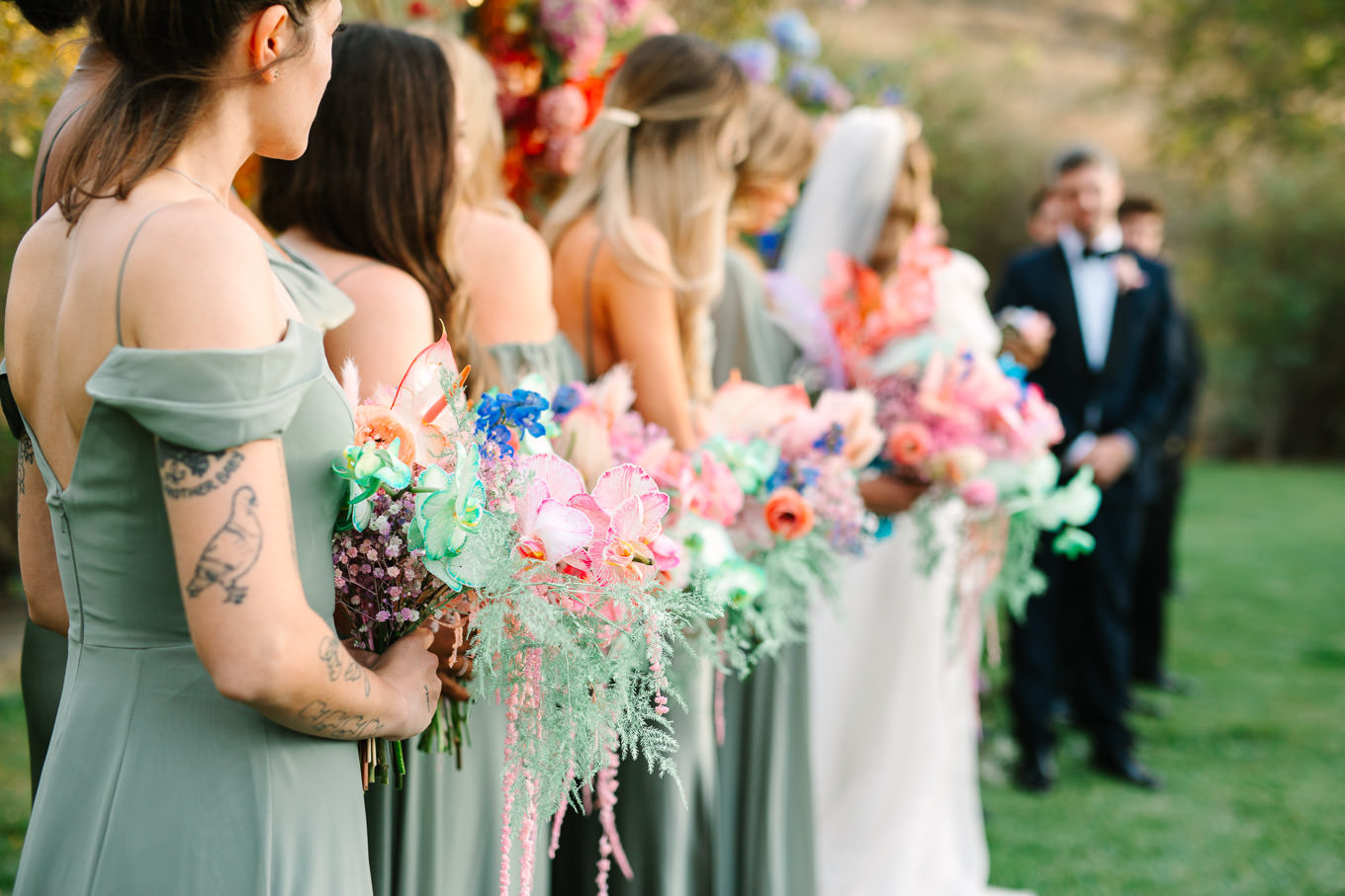 Colorful bridesmaid bouquets during ceremony | Colorful and quirky wedding at Higuera Ranch in San Luis Obispo | #sanluisobispowedding #californiawedding #higueraranch #madonnainn   
Source: Mary Costa Photography | Los Angeles